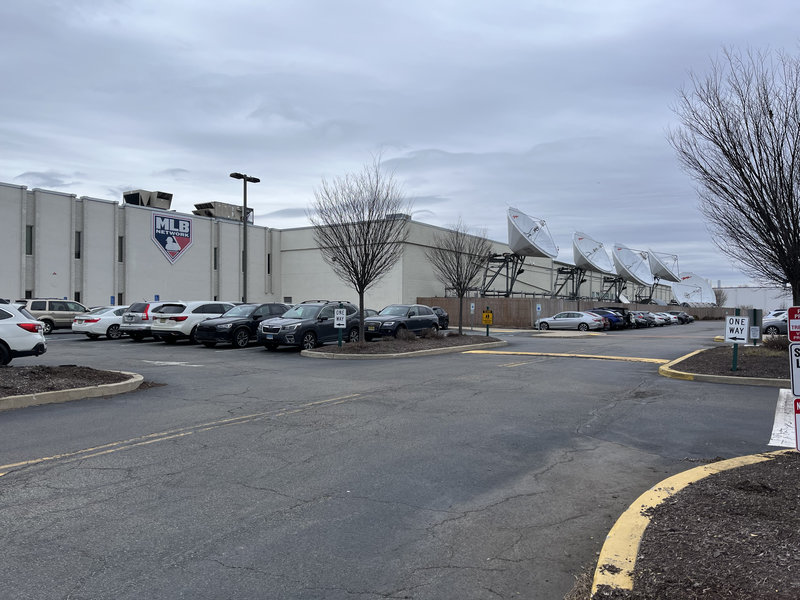 A windowsless building the MLB logo on the side, some satellite dishes on the
side.