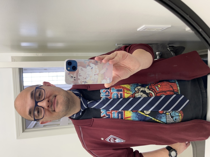 A very young 40-something, wearing a tie and a Mario Kart tshirt.