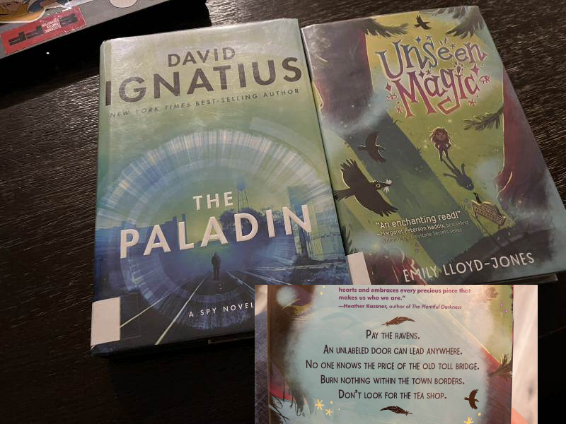 A photo of two books: a spy novel, and a children's book.